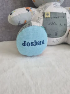 close-up of a personalised memory bear made from pale blue baby clothes